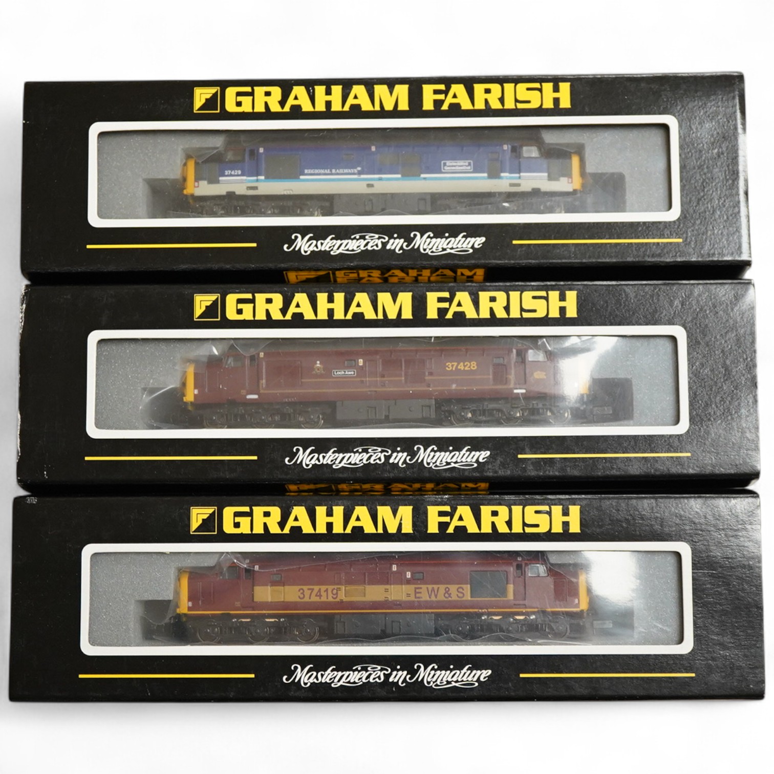 Three boxed Graham Farish N gauge railway Class 37/4 Co-Co diesel-electric locomotives; a Scottish EWS, Loch Awe (371151), a Regional Railways, Eisteddfod Genedlaethol 37429 (371154), and an EWS, 37419 (371153).
